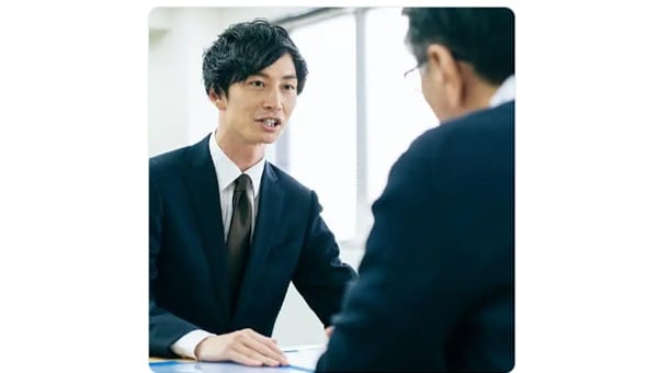 Man in suit talking to another man