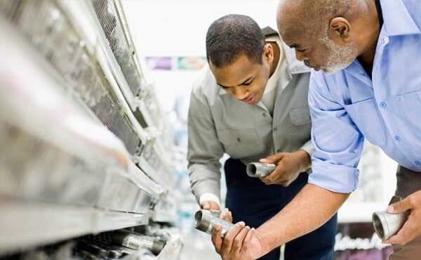 men looking at metal pipes