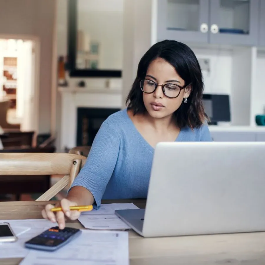 woman in blue sweater using a laptop and smarphone